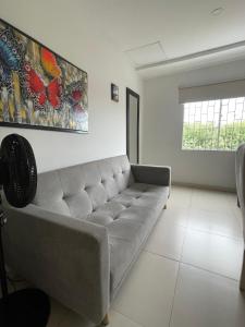 a living room with a couch and a painting on the wall at DuoCentro - Apartamento en el Punto Ideal in Montería