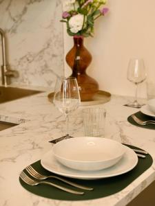 a table with a plate and glasses and a vase with flowers at Casa Luce Como in Como +18 photos