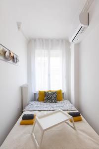 a white bedroom with a bed and a table at TOP Location Studio at Deák Sqr in Budapest