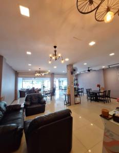 a living room with couches and tables and a chandelier at Moonlight Inn Room in Pattaya South