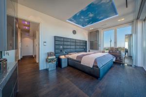 Un dormitorio con una cama grande y una ventana grande. en Munichs No1 Luxury Sky Terrace Penthouse with Unlimited Panoramic City and Alps Views, en Múnich