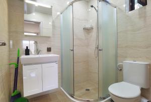 a bathroom with a shower and a toilet and a sink at Cabacum Pleasure Beachfront Apartments in Varna City