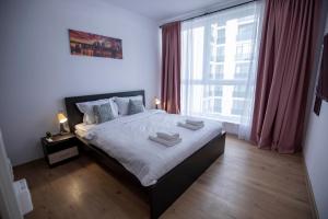 a bedroom with a bed and a large window at Luxe Pearl Towers in Bucharest