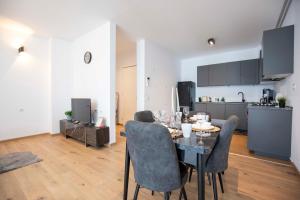 a dining room with a table and chairs and a kitchen at Luxe Pearl Towers in Bucharest