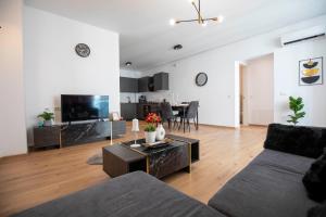 a living room with a couch and a table at Luxe Pearl Towers in Bucharest