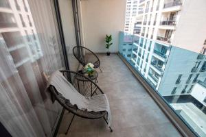 a balcony with two chairs and a window at Luxe Pearl Towers in Bucharest
