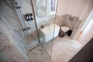 a bathroom with a shower with a sink and a toilet at Luxe Pearl Towers in Bucharest +23 photos