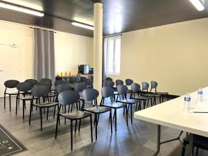 a room with a bunch of chairs and tables at HOTEL & SPA Le Renard Centre in Chalons en Champagne