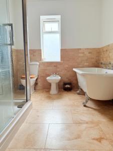 a bathroom with a tub and a toilet and a sink at Moorlands in Bartley