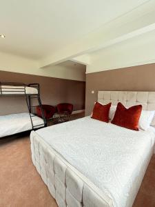 a bedroom with a large white bed with red pillows at Moorlands in Bartley