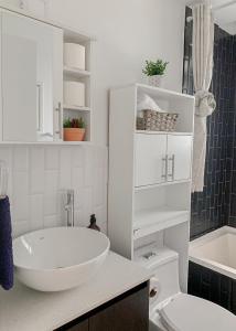 a white bathroom with a sink and a toilet at Narama 3 - Apartamento cerca del aeropuerto - Zona 13 de la Ciudad de Guatemala in Guatemala