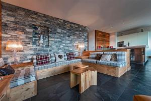 a living room with a couch and a stone wall at Le Cervin Rouge in Crans-Montana