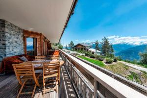 a room with a balcony with a table and chairs at Le Cervin Rouge in Crans-Montana