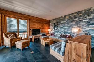 a living room with a couch and a tv at Le Cervin Rouge in Crans-Montana