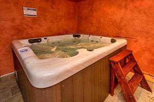 a bath tub in a room with a wooden stool at Le Cervin Rouge in Crans-Montana +25 photos
