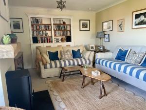 a living room with two couches and a tv at Castle Reach Newport, Pembrokeshire in Newport Pembrokeshire