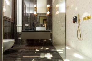 ein Badezimmer mit Badewanne, Waschbecken und Dusche in der Unterkunft Baluardo Boutique Apartments in Clusane sul Lago