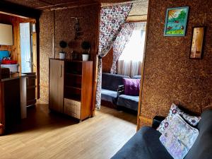 a living room with a couch and a mirror at Domki Alkana - domek 4 in Nowęcin