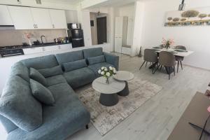 a living room with a blue couch and a table at Isa Residence - Otopeni Airport & Therme I Libertatii Gardens - free pool facilities in Otopeni