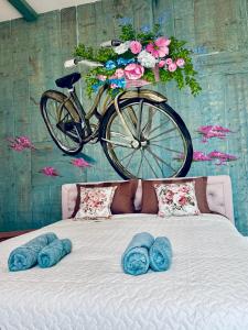 a bike hanging above a bed with blue pillows at Sunset Lovers Residence in Liepāja