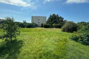 a building in the middle of a grass field at Southwest Sea Apartment in Liepāja