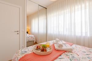 ein Tablett mit Essen auf einem Bett im Zimmer in der Unterkunft Stylish & Spacious Apartment by HostWise in Porto