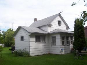 a white house with a gray roof on a yard at Canora Vacation Home in Canora