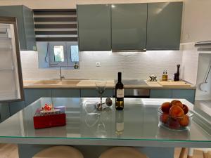 a kitchen with a glass table with a bottle of wine at WoodHome in Kalamitsi +22 photos