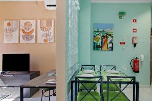 ファロにあるFaro Downtown Suites - Vila Adentroのテーブルとテレビのあるダイニングルーム