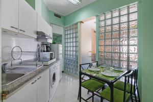 ファロにあるFaro Downtown Suites - Vila Adentroのキッチン(テーブル、椅子2脚、シンク付)