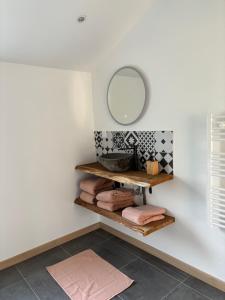 a bathroom with a mirror and a shelf with towels at maison entière piscine balnéo in Lailly-en-Val
