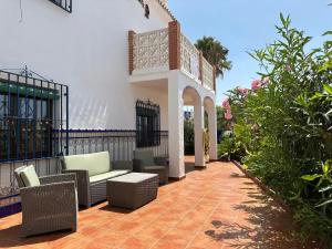 a patio with a couch and chairs and plants at La Chinita in Nerja