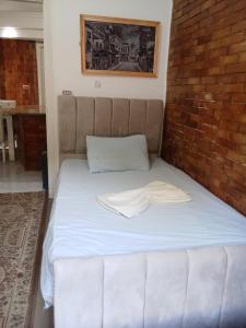 un lit dans une chambre avec un mur de briques dans l'établissement 1B V150B Chalet 3bedrooms basement green beach, à El Alamein 45 autres photos