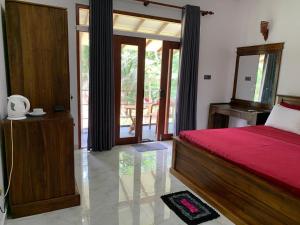 a bedroom with a bed with a red bedspread at Sea View Villa Bentota, Induruwa in Induruwa