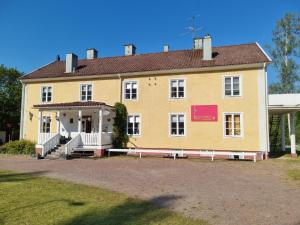a yellow building with a sign in front of it at Lönneberga Vandrarhem & Hostel in Lönneberga