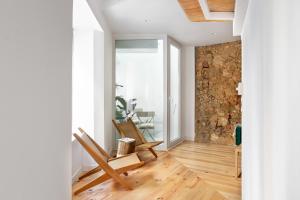 a room with two chairs and a stone wall at GuestReady - Fabulous studios near Pink Street in Lisbon
