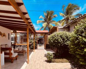 an open patio with palm trees and a house at Hotel Coral Blanco with high speed internet Starlink and Galapagos Tour Operator in Puerto Villamil