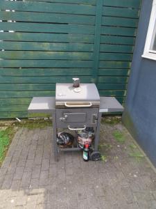 a grill sitting on a bench next to a green wall at Hotel Gästehaus Lutgen in Waldfeucht