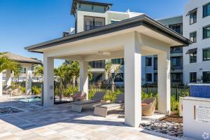 a gazebo with chairs and tables in front of a building at Landing Palmetto Apartments in Palmetto