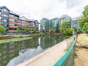 a river in a city with tall buildings at Stylish Central 1-Bed Flat with Private Balcony Pass the Keys in Reading