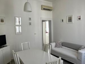 a white living room with a couch and a table at Marisa Apartment in Reggio di Calabria