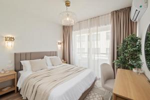 a bedroom with a bed and a desk and a window at The Serene Suite in Larnaka