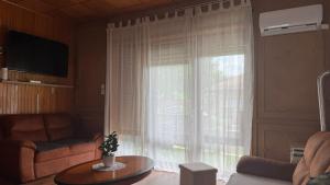 a living room with a large window with curtains at Villa Negra 1 in Balatonfenyves