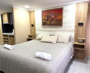 Un dormitorio con una cama grande con un cuadro en la pared. en ALTURAS apart-hotel, en El Bolsón