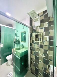 a bathroom with a shower with a sink and a toilet at Lindo estúdio frente à praia in Santos