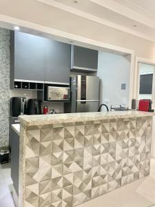 a kitchen with stainless steel appliances and a counter top at Lindo estúdio frente à praia in Santos