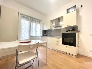a white kitchen with a table and a stove at La casa di Mariposa in Sanremo
