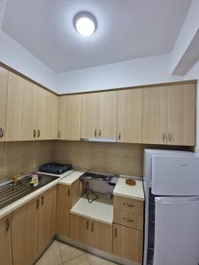 a kitchen with wooden cabinets and a white refrigerator at Villa Alvara in Vlorë