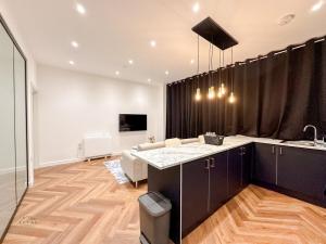 ルートンにあるModern 2 Bedroom Flat in Luton Town Centreのリビングルーム(ソファ、テーブル付) +1枚の写真