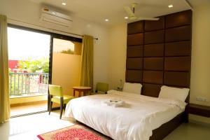 a bedroom with a bed and a large window at Maitri Retreat in Panchgani +22 photos